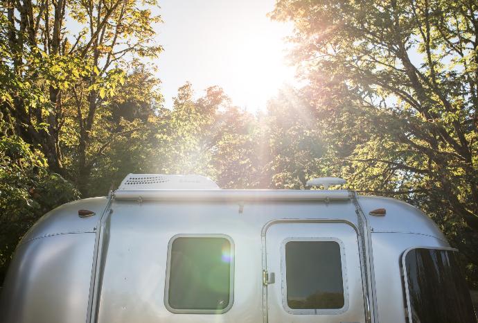 silver RV trailer near trees