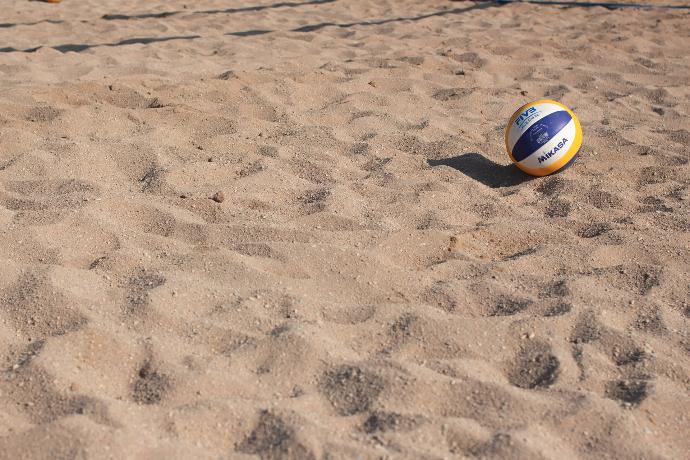 blue, yellow, and white volleyball on sand